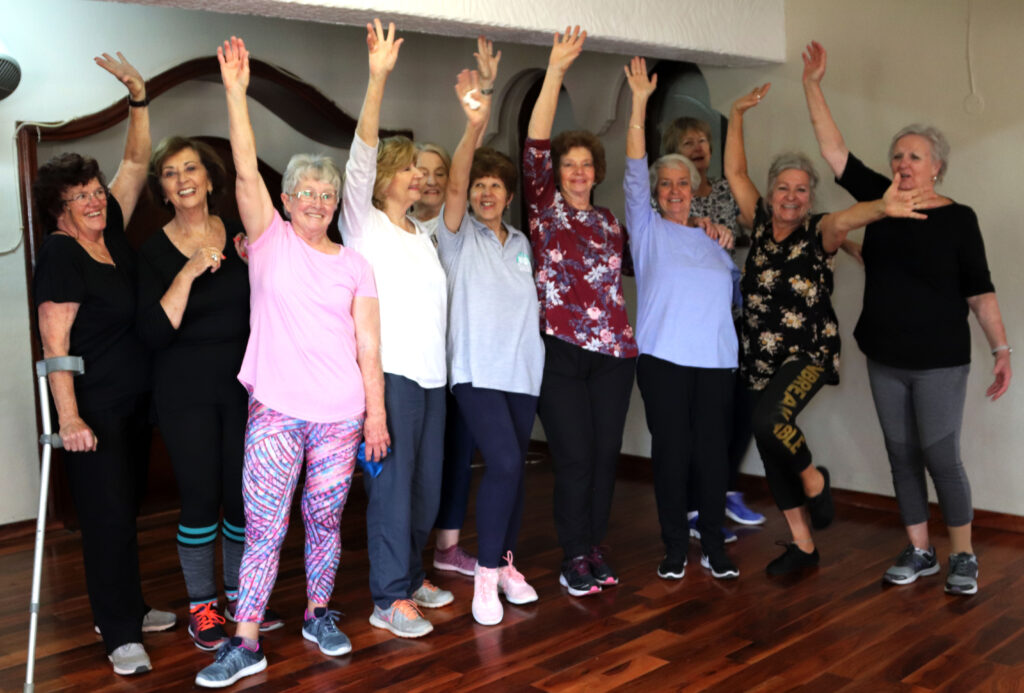 Indoor fitness class for people over 60 celebrating movement together.