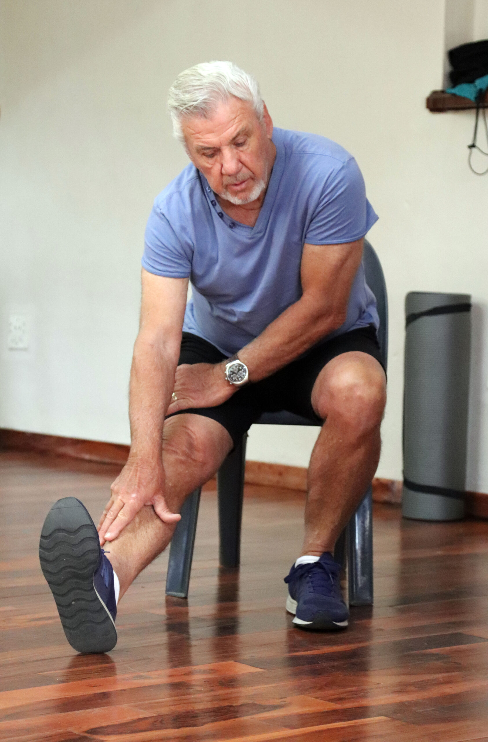 Older adult doing a seated hamstring stretch during a Silver Fit exercise class.