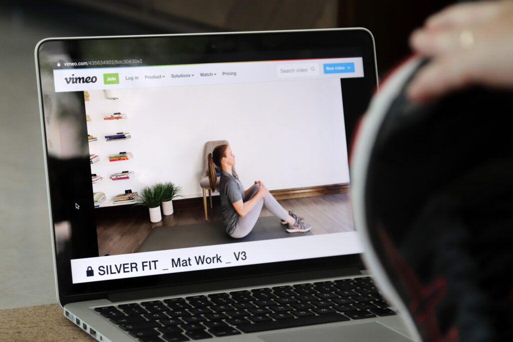 Silver Fit online exercise class playing on a laptop for people over 60 exercising at home.
