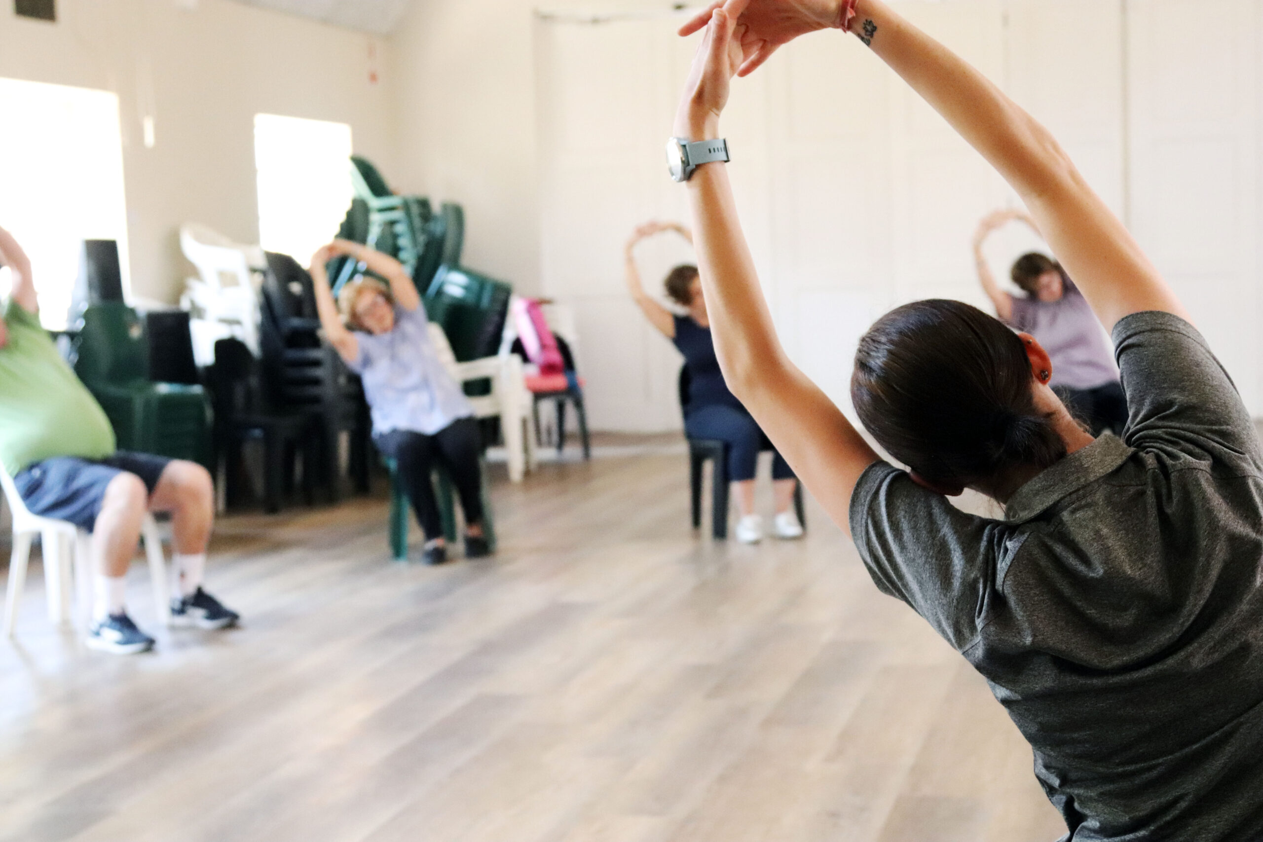 Older adults doing gentle stretching exercises during a Silver Fit class after returning to exercise.